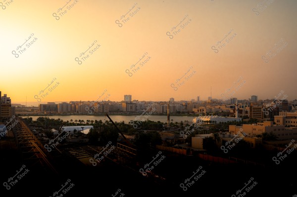 منظر لمدينة جدة عند الغروب يظهر فيه المباني والواجهة البحرية تحت سماء برتقالية.