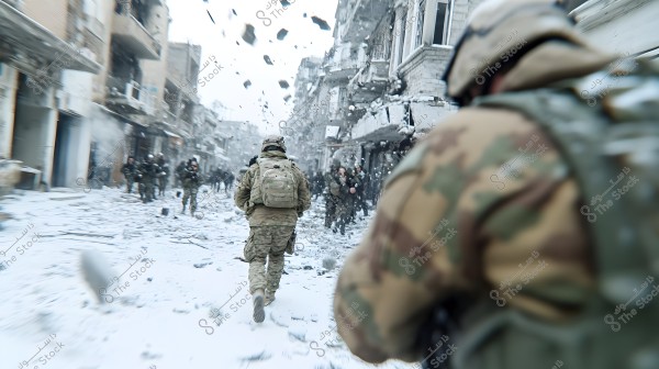 Soldiers in full military gear walk down a devastated street under falling debris from an explosion or shelling. The buildings on either side are heavily damaged, and the winter scene is evident with snow or dust accumulation. The group appears alert in a war zone environment.
