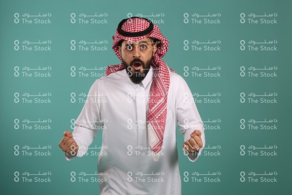 بورتريه شاب سعودي متحمس يرتدي الزي السعودي التقليدي، شاب يعبر عن الانتصاره والفرحة