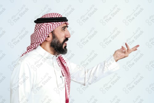 بورتريه رجل سعودي كبير بالسن يرتدي الزي الرسمي التقليدي على خلفية بيضاء يقوم بعمل اشارات بيديه وهو مبتسم ، حزين، غاضب، صور تذكارية ، توثيق لحظة سعيدة.