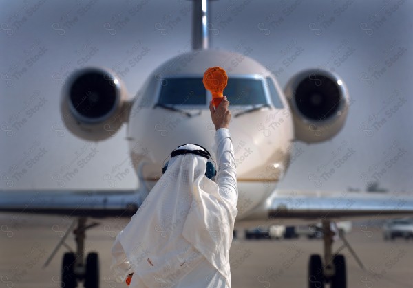 A shot of a man waving to the plane captain and directing him, flying, taking off and landing.