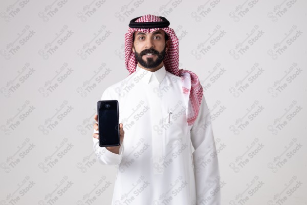 Portrait of a Saudi man holding an automatic payment device and making different expressions