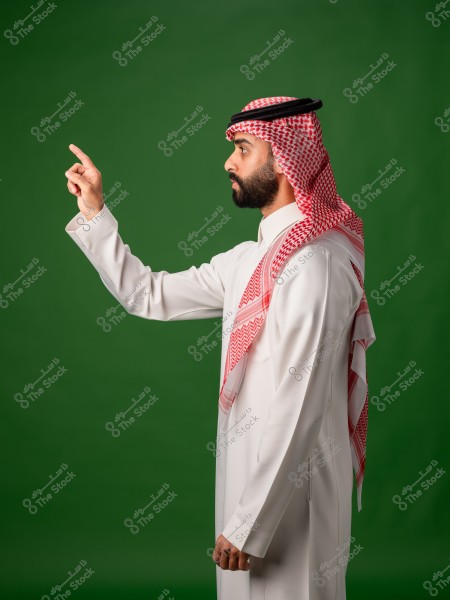 رجل يرتدي الثوب الخليجي والغترة والعقال يشير بإصبعه على خلفية خضراء.