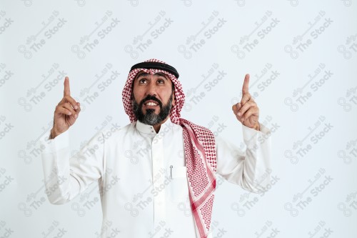 بورتريه رجل سعودي كبير بالسن يرتدي الزي الرسمي التقليدي على خلفية بيضاء يقوم بعمل اشارات بيديه وهو مبتسم ، حزين، غاضب، صور تذكارية ، توثيق لحظة سعيدة.