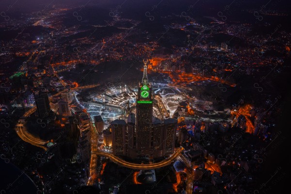 An aesthetic aerial shot of Mecca showing the clock tower at night, the clock tower, the Grand Mosque, buildings and landmarks, the Holy Mosque of Mecca , Baitullah Al-Haram.