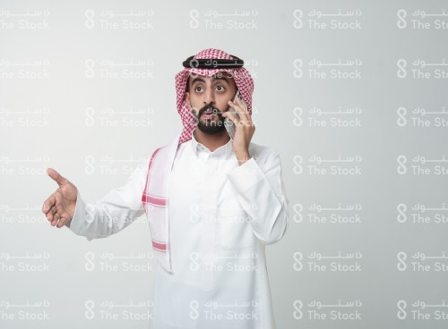 رجل سعودي يقوم بإشارات وهو يتحدث على الهاتف