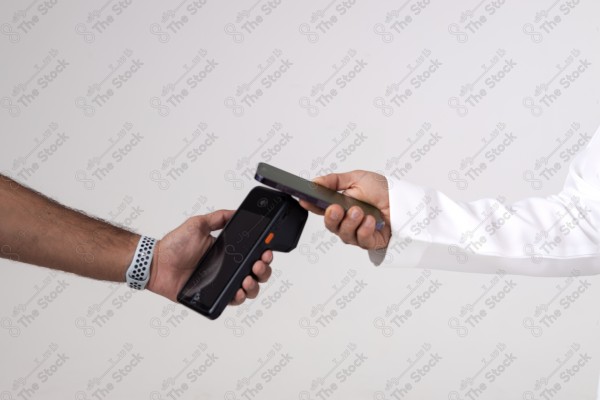 Portrait of a Saudi man holding a card and making automatic payments on a white background