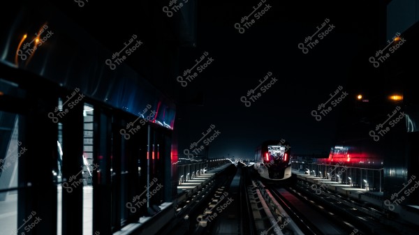 A modern train moving on railway tracks at night, with light reflections on the surrounding walls.