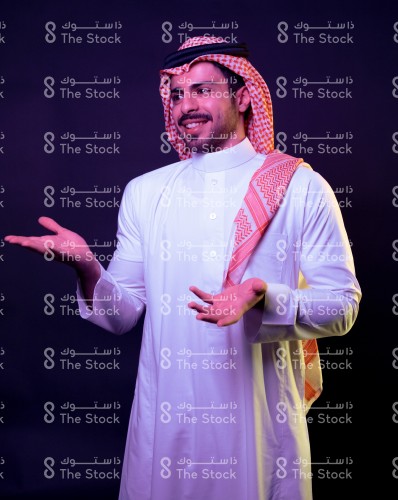 بورتريه رجل سعودي يرتدي الثوب يتفاعل بحركات تعبيرية بيديه