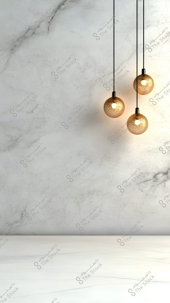 Three pendant lights with a mesh metal design hanging from the ceiling against a white marble background. The overall design is minimalist and modern, with warm colors providing a sense of coziness and comfort.