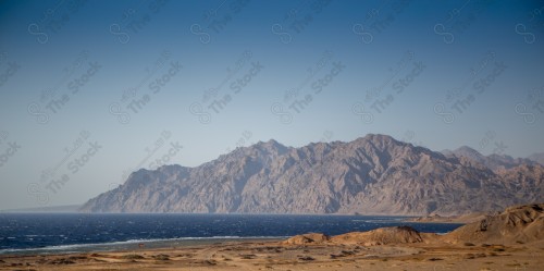 صورة لجبال طيب اسم في شمال مقنا غرب مدينة البدع في السعودية ، الجبال والتكوينات الصخرية في تبوك شمال المملكة العربية السعودية ، جمال اشجار النخيل على مدخل الجبل.