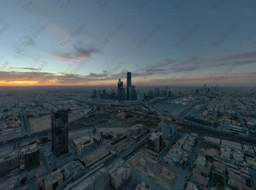 A shot showing the buildings and landmarks of the financial center of the city of Riyadh, in front of it a group of residential houses, and the sky is cloudy.