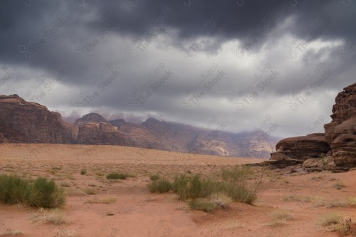 لقطة لسلسلة من الجبال محاطه بالغيوم السوداء.