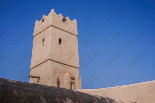 برج تراثي مبني من الطين في ساحة البجيري بالدرعية التاريخية وتظهر السماء صافية نهارًا