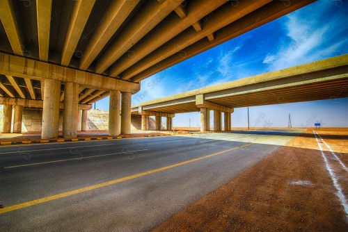 لقطة لشبكة الطرق المعبدة وجسر معلق في مدينة الرياض نهارًا.