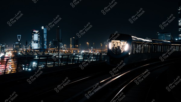 منظر ليلي لأفق الرياض مع قطار مترو مضاء يمر في المقدمة.