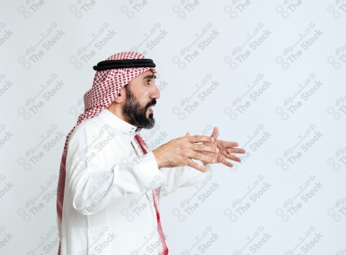 بورتريه رجل سعودي كبير بالسن يرتدي الزي الرسمي التقليدي على خلفية بيضاء يقوم بعمل اشارات بيديه وهو مبتسم ، حزين، غاضب، صور تذكارية ، توثيق لحظة سعيدة.