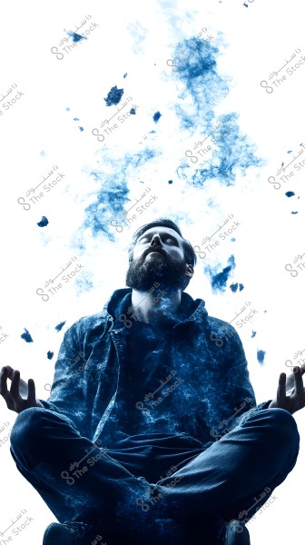 A photo of a man sitting cross-legged in a meditative pose, wearing a dark jacket and jeans. The background is white with artistic blue smoke effects surrounding him, creating a magical and mysterious atmosphere in the image.