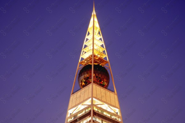 A snapshot showing the Al-Faisaliah Tower, one of the buildings and landmarks of the city of Riyadh, and the sky appears clear, skyscrapers, towers, and geometric shapes.