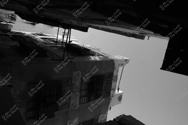 Black and white image of an old building with dilapidated windows and balconies.