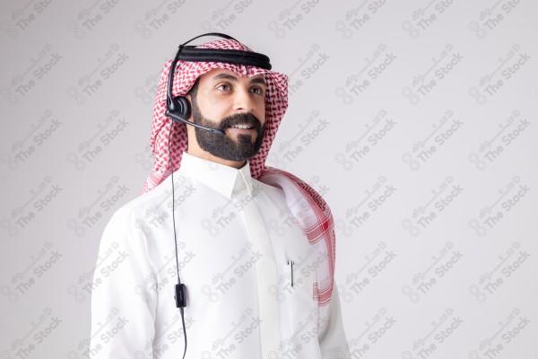 بورتريه رجل سعودي يلبس سماعة الرأس ويقوم بالتواصل عبر السماعة - خدمة العملاء ، مكالمة هاتفية