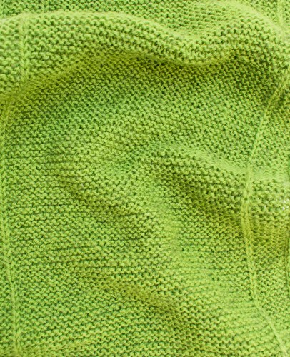 A close-up of a green textile for knitting clothes, fabrics and textiles.