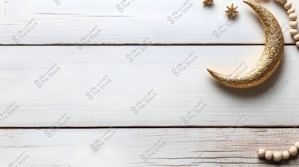 An image of a decorative golden crescent on a white wooden surface. The crescent is positioned on the right side of the image, surrounded by small white round beads and two golden stars. The image conveys a Ramadan or Islamic theme.