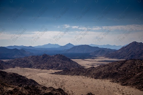 صورة لجبال طيب اسم في شمال مقنا غرب مدينة البدع في السعودية ، الجبال والتكوينات الصخرية في تبوك شمال المملكة العربية السعودية ، جمال اشجار النخيل على مدخل الجبل.