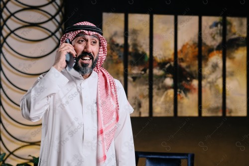 رجل سعودي يقوم بتفاعلات مختلفة باستخدام الجوال ، رجل سعودي يقوم بإجراء مكالمة هاتفية وهو مبتسم