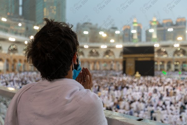 A snapshot of a Umrah performer performing supplications at the Holy Kaaba, pilgrims and Umrah performers, Hajj and Umrah.