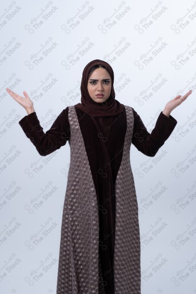 A young Saudi woman wearing an abaya and hijab, looking angry