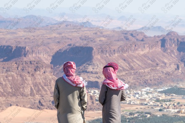 An aesthetic shot of people at the highest mountain peak in Al-Ula Governorate, Saudi Arabia, tourist places in Saudi Arabia, green palm tree farms.