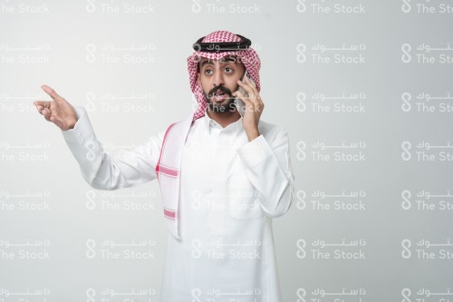 رجل سعودي يقوم بإشارات وهو يتحدث على الهاتف