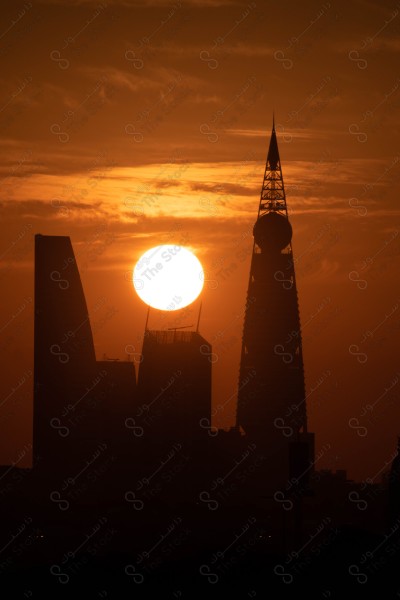 A snapshot showing the sunrise in Riyadh, the buildings and landmarks of the city of Riyadh, in front of it is a group of towers and behind it is the Al-Faisaliah Tower, and the sky appears clear, sunrise, Riyadh towers,