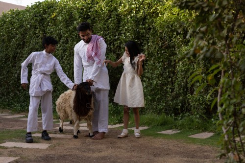 A Saudi family gathered in the eid , the eid sheep, the sacrifice, aodhiyah, the eid , visits and the family gathering, the customs of the eid in the Saudi society, a happy family atmosphere, eid and occasions.