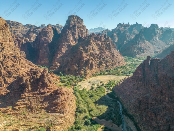 An aerial shot of Wadi Al-Disa in Tabuk, showing the mountains during the day, Saudi valleys, and nature in Saudi Arabia.