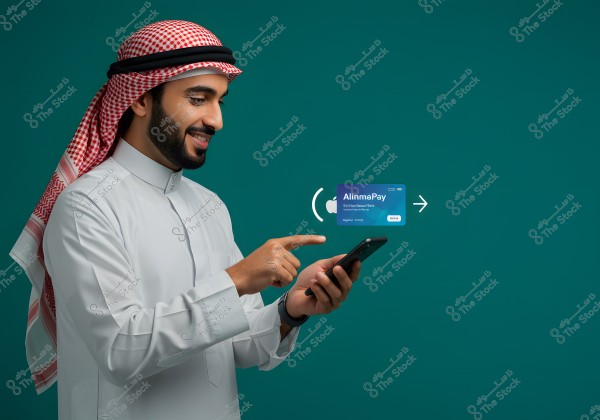 Image of a man wearing traditional Saudi attire, including a white thobe and a red checkered headscarf with a black agal, using a smartphone. Next to him, an electronic payment card labeled \"AlinmaPay\" is visible. The background is green.