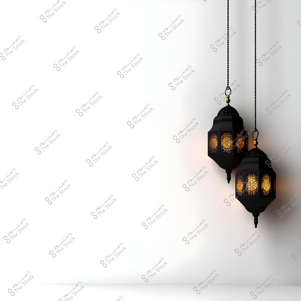 Two hanging metal lanterns in black with an oriental design featuring intricate decorative patterns. The lanterns emit a warm, orange light, adding a touch of aesthetics against the plain white background.