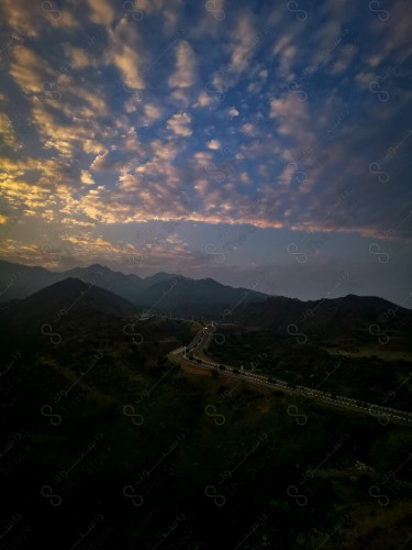 A shot of a series of mountains in Faifa governorate surrounded by agricultural terraces during sunset