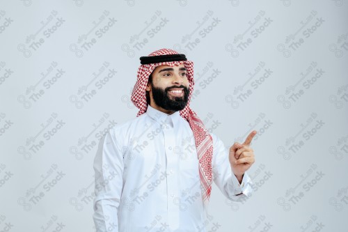 Portrait of a Saudi man in free uniform on a white background making gestures with his hands while smiling, souvenir photos, documenting a happy moment.