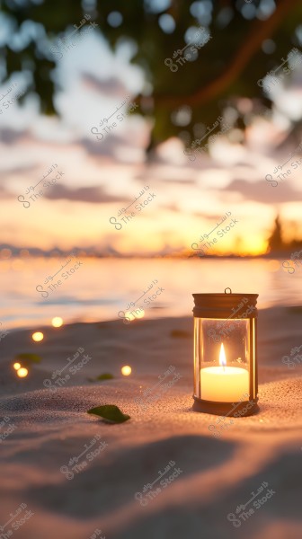 A lit lantern glowing on a sandy beach at sunset. The warm light creates a serene reflection against the calming colors of the sunset in the background. Some green leaves are scattered on the sand, with a subtle glow appearing near the lantern.
