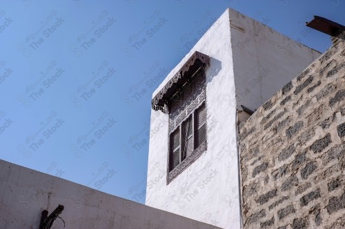 Detail of an old wooden window in a mud wall, decorative wooden window.