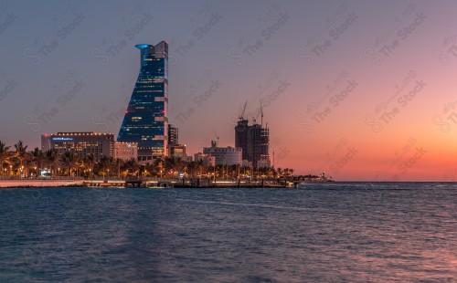 A picture of a building on the beach in Jeddah at sunset, the reflection of the sun's rays