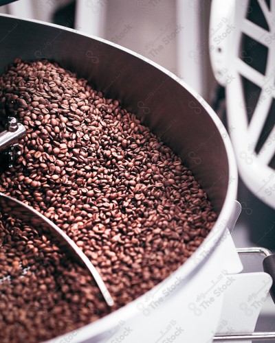 Coffee roasted from dark and aromatic coffee beans in a modern roasting machine.