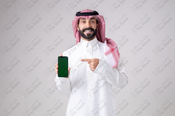 Portrait of a Saudi man holding a phone, pointing at the phone and making different expressions - green screen