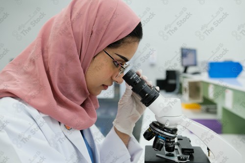 Saudi doctor in a hospital, working in a laboratory that analyzes a sample on a microscope, working in the health sector, providing medical consultations and health services, medicine and health care