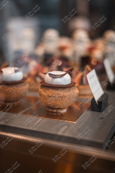 حلوى معروضة في متجر, تتكون من قاعدة كريمية وزينة من الشوكولاتة.