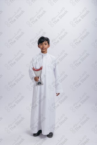 Portrait of a Saudi child on a white background making gestures with his hands while smiling, souvenir photos, ، documenting a happy moment, Eid candy, Eid gifts, Eidiyat, incense