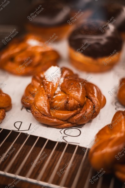 Sweet braided pastry with powdered sugar on top on a bakery rack.