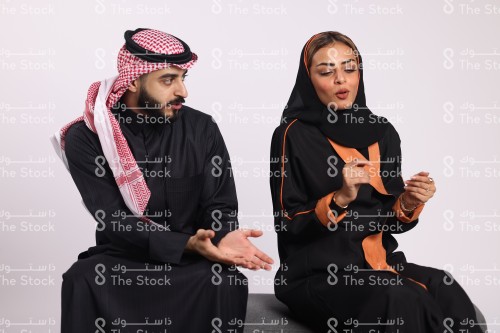 بورتريه حوار بين امرأة سعودية ترتدي الحجاب مع رجل سعودي يرتدي الزي السعودي التقليدي، شاب وفتاة يتناقشون